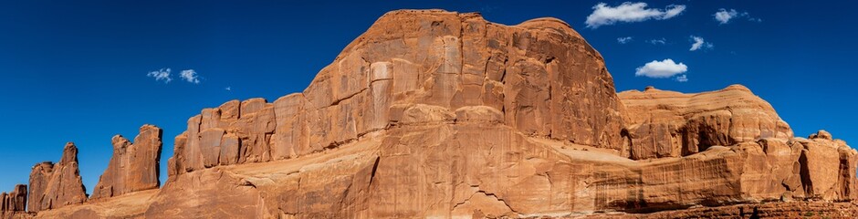 Panorama shot of red sandstone massif and monoliths against blue sky in Archen national park in Utah, america