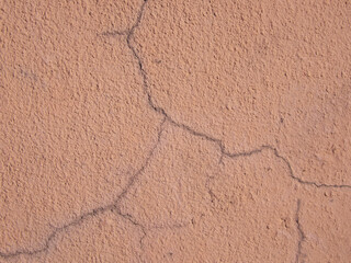 Light brown wall. Cracks in the plaster.