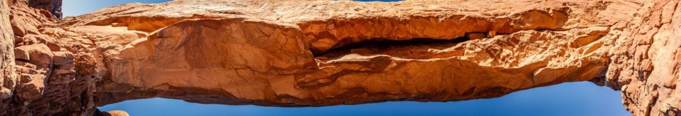 Close up of upper part of red sandstone arch against sky in Arches national park in Utah, America