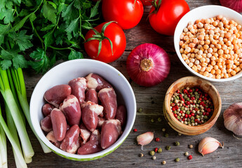 Ingredients for pea soup with chicken hearts on a wooden table. View from above.