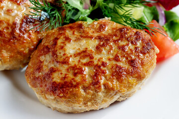 Homemade cutlets are grilled. A fresh vegetable salad.