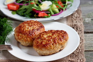 Homemade cutlets are grilled. A fresh vegetable salad.