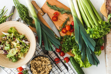 The ingredients for the salad are on the rack. Lettuce, leeks, parsley, tomatoes. Cooking process. Clutter on the kitchen table