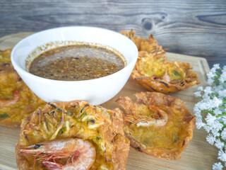 Fried prawn fritters or commonly known as cucur udang served with spicy peanut sauce. Selective focus points. Blurred background