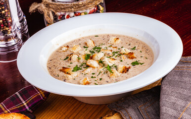 Mushroom cream soup with croutons in white plate