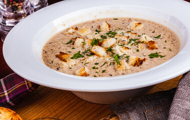 Mushroom cream soup with croutons in white plate