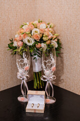 Bridal bouquet with orange roses. Wedding gold rings. Wedding glasses. Groom's boutonniere