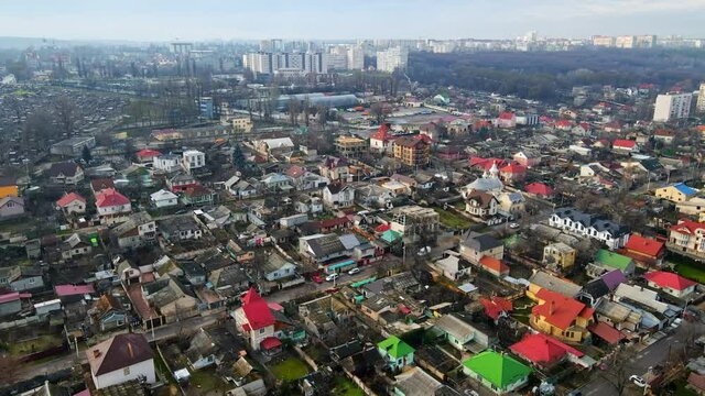 Aerial drone view of a residential distict in Chisinau, Moldova. Multiple buildings, road, moving cars, Cloudy weather, bare trees, winter