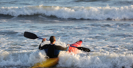 athlete with canoe, among the waves of the sea