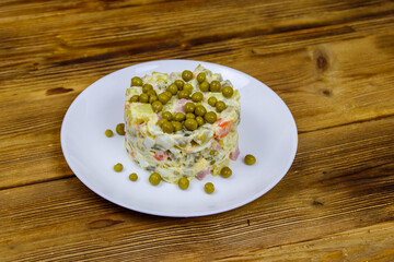 Traditional Russian festive salad Olivier on wooden table