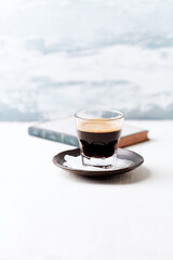 Coffee in glass cup on bright wooden background. Copy space.