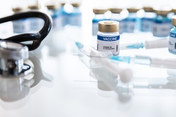 Coronavirus vaccine vials, ampoules and syringe on lab bench. Covid-19 vaccine research.