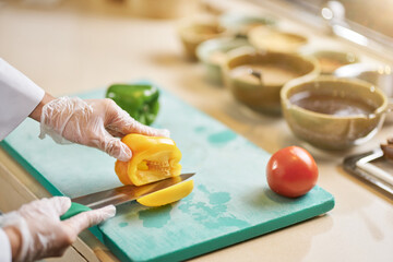 Skilled chef cutting into a fresh bell pepper