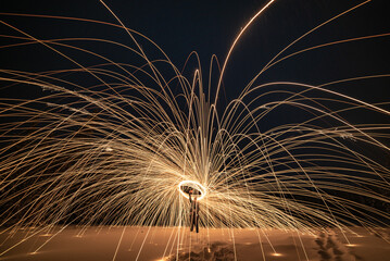 A winter snowy landscape with amazing sparking, steel wool effect shooting sparks across the frozen landscape at night. Unique background, wallpaper abstract view. 