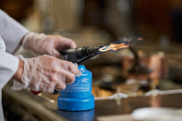 Person using a gas burner in the kitchen