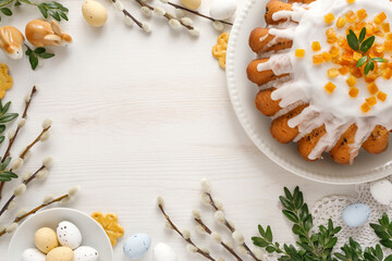 Easter background with traditional yeast cake and festive decoration on white wooden background with copy space. 