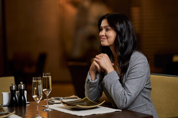 Lovely young lady smiling at the restaurant table