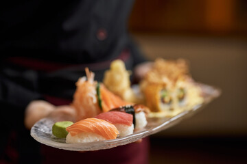 Freshly-made sushi set being delivered to restaurant table
