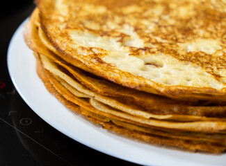 a stack of pancakes on a white plate