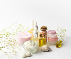 Spa and wellness concept. Set of natural cosmetic products such as serums, oils, cosmetic clay, aromatic candles and massage stones on white background Skin care concept