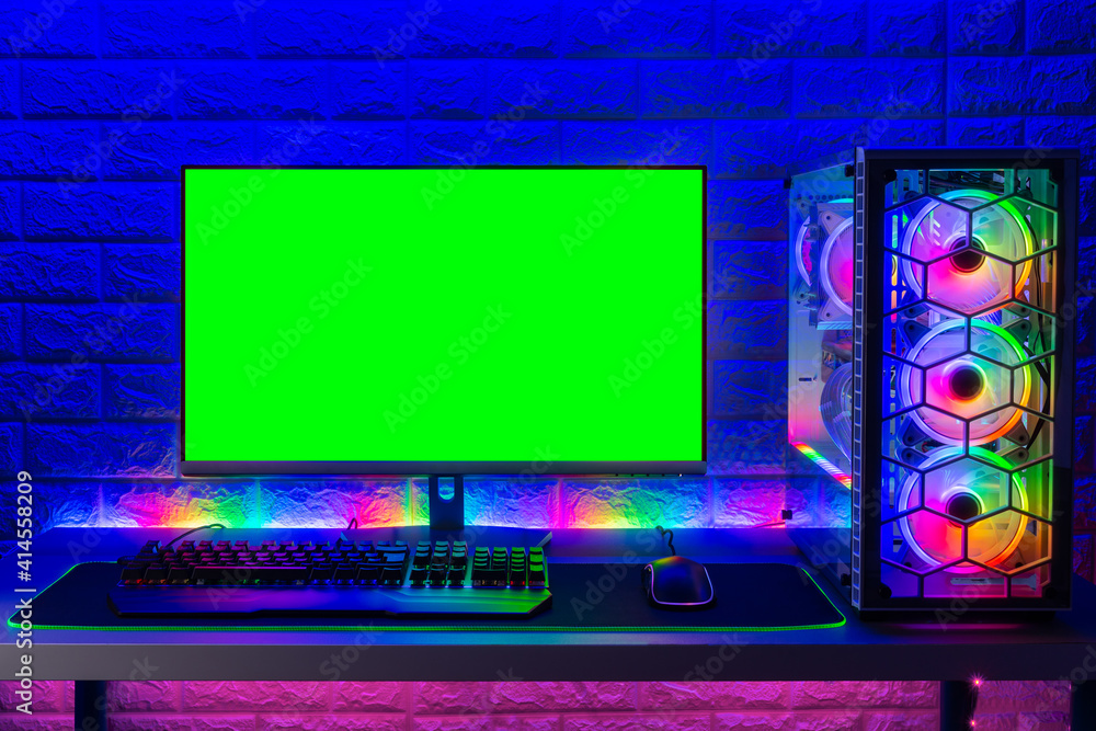 Poster colorful bright illuminated rgb gaming pc with keyboard mouse monitor with green screen copy space f