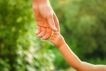 the parent holding the child's hand with a happy background