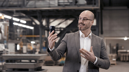 Business Video Call in industrial plant with mobile phone smartphone