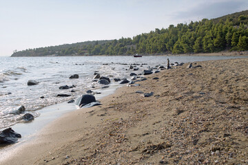 Panorama view at the sandy rocky beach in small village Psakoudia in Greece.Copy space, text space, empty beach.