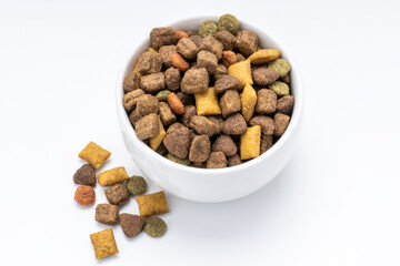 domestic animals dry food at white bowl isolated on white background. dried cat feed cut out. above view