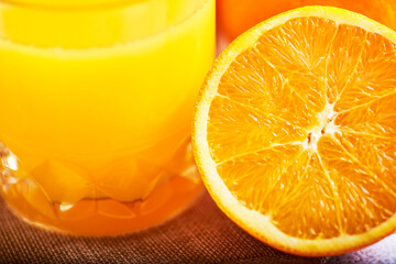 
orange juice in a glass container with some oranges