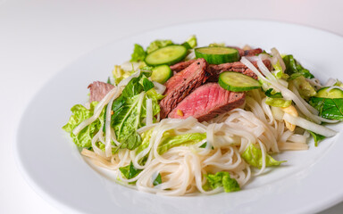 Roasted stake with rice noodle and fresh Napa salad. Homemade summer healthy eating food.