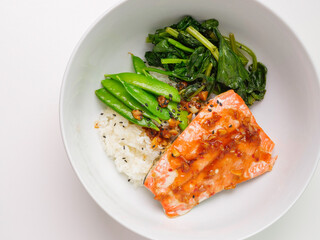 Homemade rustic salmon and spinach rice bowl with chili lime teriyaki sauce