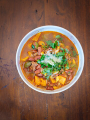 Chili with sweet potato, scallion, and cheese on rustic table 