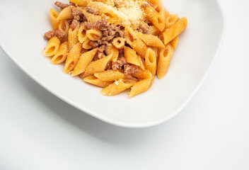 Homemade dish of delicious italian penne pasta with slowcooked bolognese ragu sauce and cheese. Top view. Concept Italian Cuisine