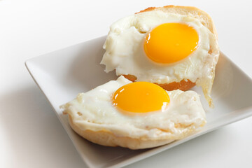 Two pieces of fried sunny side eggs on English Muffins