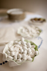 White wedding sugared almonds in a fine ceramic bowl.