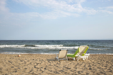 Two beach chairs on the white sand with blue sky and summer sea background. Summer, Vacation, Travel and Holiday concept.Psakoudia,Greece.