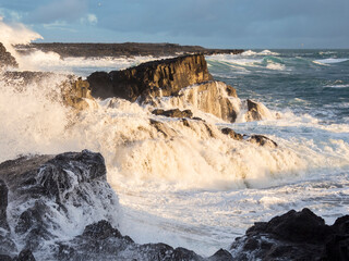 Coastline at Brimketill during stormy conditions at sunset. The coast of the north Atlantic on Reykjanes peninsula during winter, Iceland.