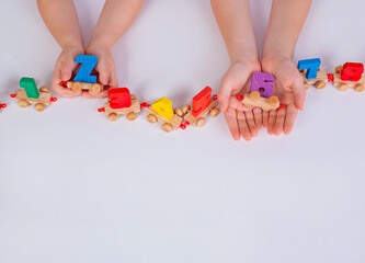 Children's hands play with a wooden toy train with numbers. The count goes from one to eight.