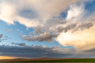 Sunset theme for sky replacement background with dark themed clouds, blue sky and sun shining on the horizon. Great for tranquil, calm, serene country or rural themed art.