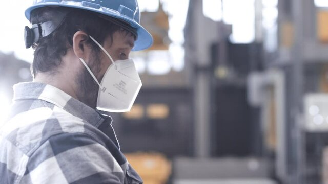 Mann mit Maske in Produktionshalle