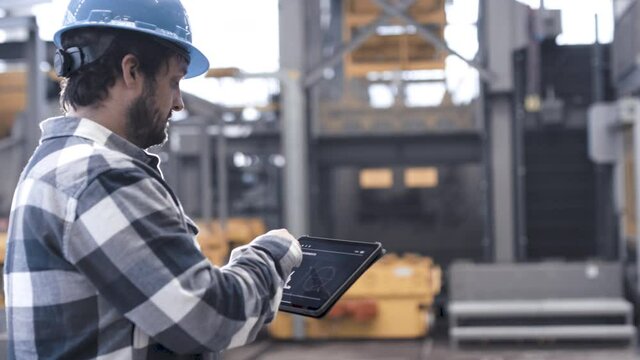 Mann bedient Tablet in smarter Produktionsanlage