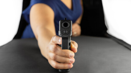 Female holding and pointing handgun at the screen.