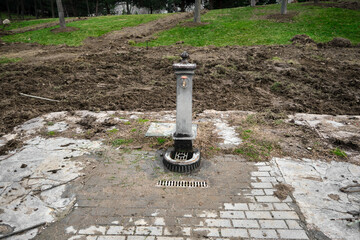 Obraz na płótnie Canvas Old and ancient style fountain for drinkable water in open botanical park in Bursa. Fountain covered by tillage soils and muds.