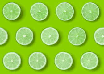 Fruit pattern of lime slices on green background. Flat lay, top view. Seamless pattern.