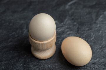 Egg cup and Two raw egg on black background