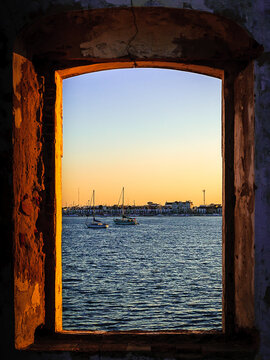 Vila Real de Santo Ant&ograve;nio (Portugal), seen from Ayamonte (Spain), with the Guadiana river and the sailboats in foreground, seen through the window opening