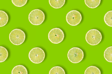  Fruit pattern of lemon slices on green background. Flat lay, top view. Seamless pattern.