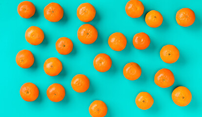 Fruit pattern of fresh mandarin on blue background. Flat lay, top view. Pop art design, creative summer concept. Citrus in minimal style.