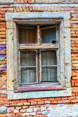 Aged wooden window and ruined brick wall